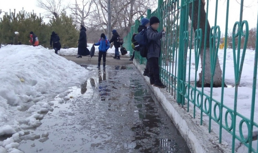 Возле омской школы № 60, где дети взбирались на забор, чтобы преодолеть лужу, откачивают воду